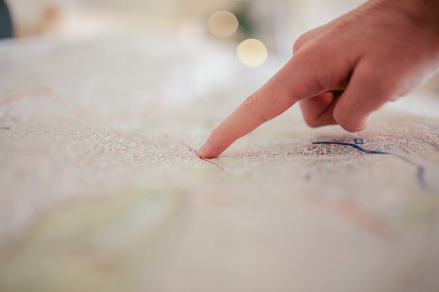 A person pointing to a location on a map. 