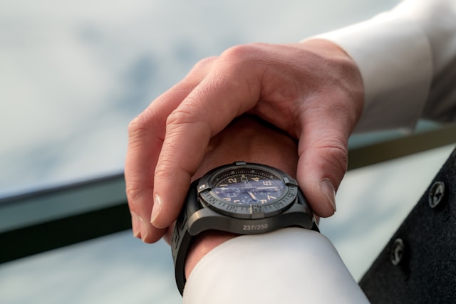 A man is looking at his watch on his left hand. 