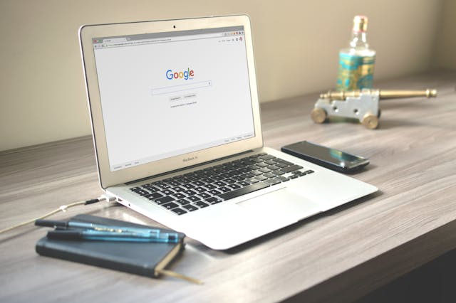 Google showing on a laptop screen that’s on a desk. 