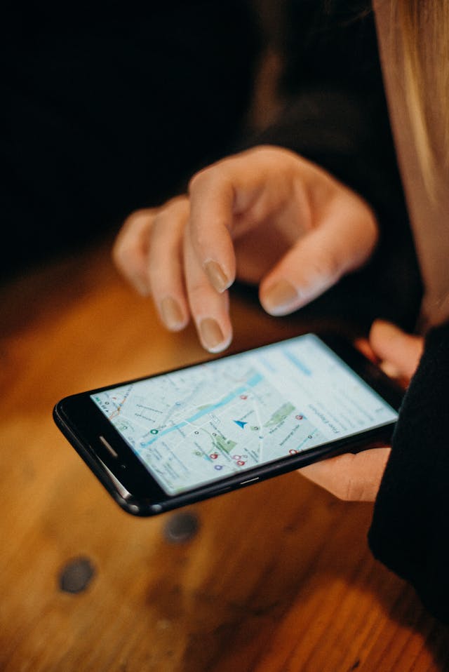 A person holding a mobile device and looking at a map. 