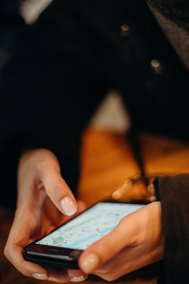 A person holding a mobile device and looking at a map. 