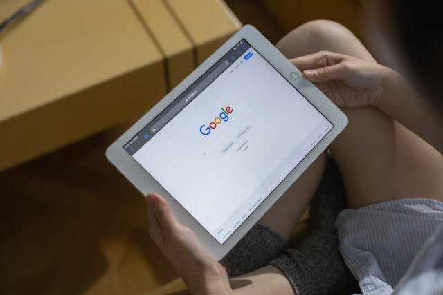 A person using a tablet and looking at Google. 
