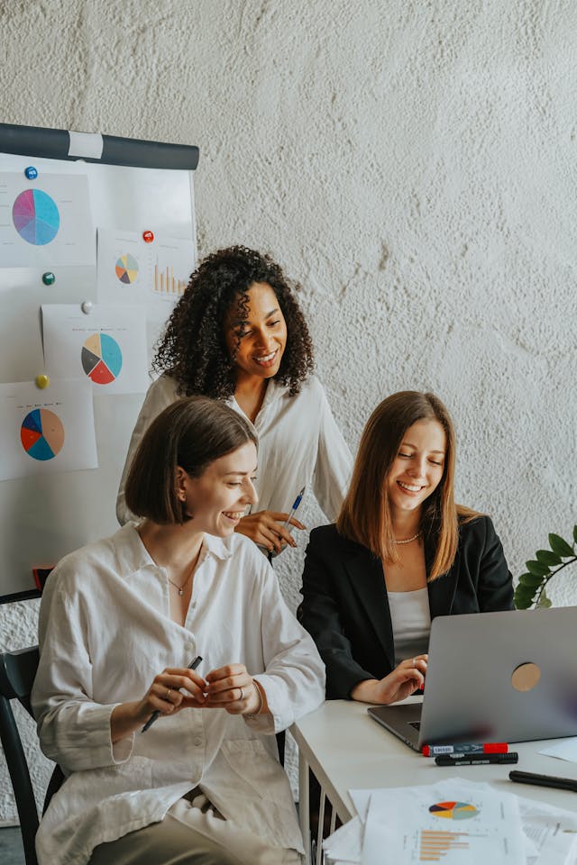 A group of women looking at a laptop. 